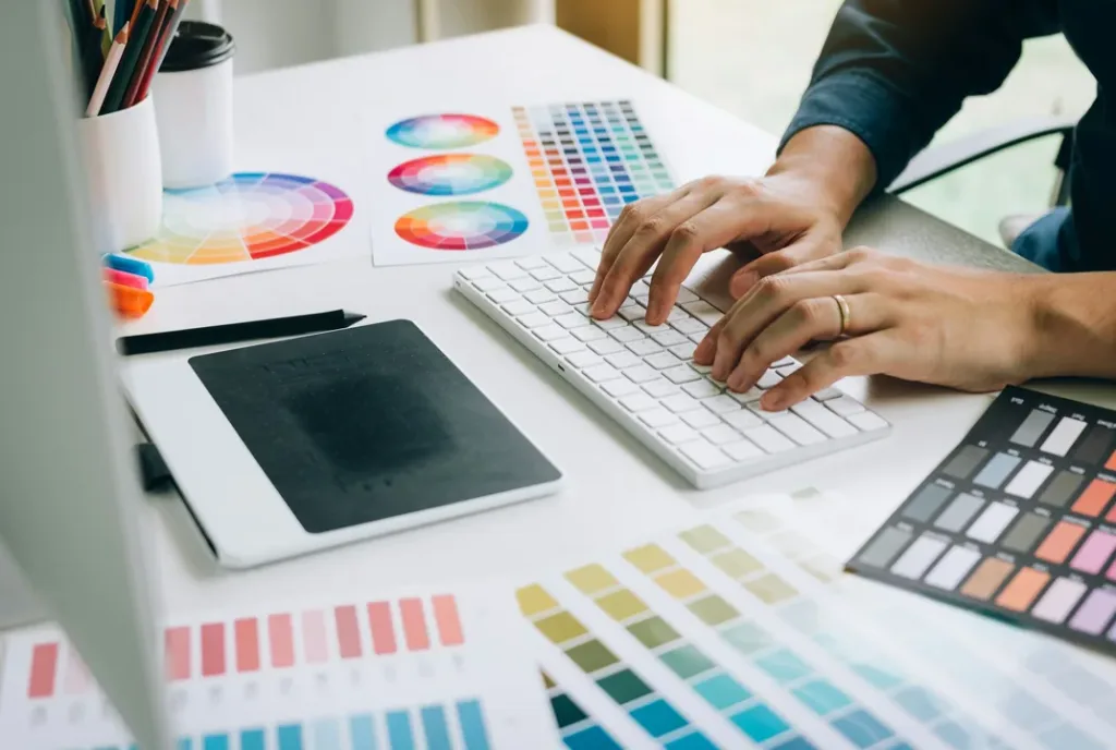 Colour swatches and a drawing tablet on a designer's desk